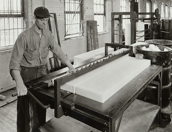 Man working in factory with a large block of soap